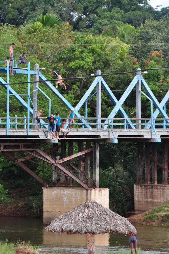 Garotos se divertem pulando da ponte (um deles está dando um mortal!) em em Ponte Alta do Tocantins, entrada do Jalapão - TO